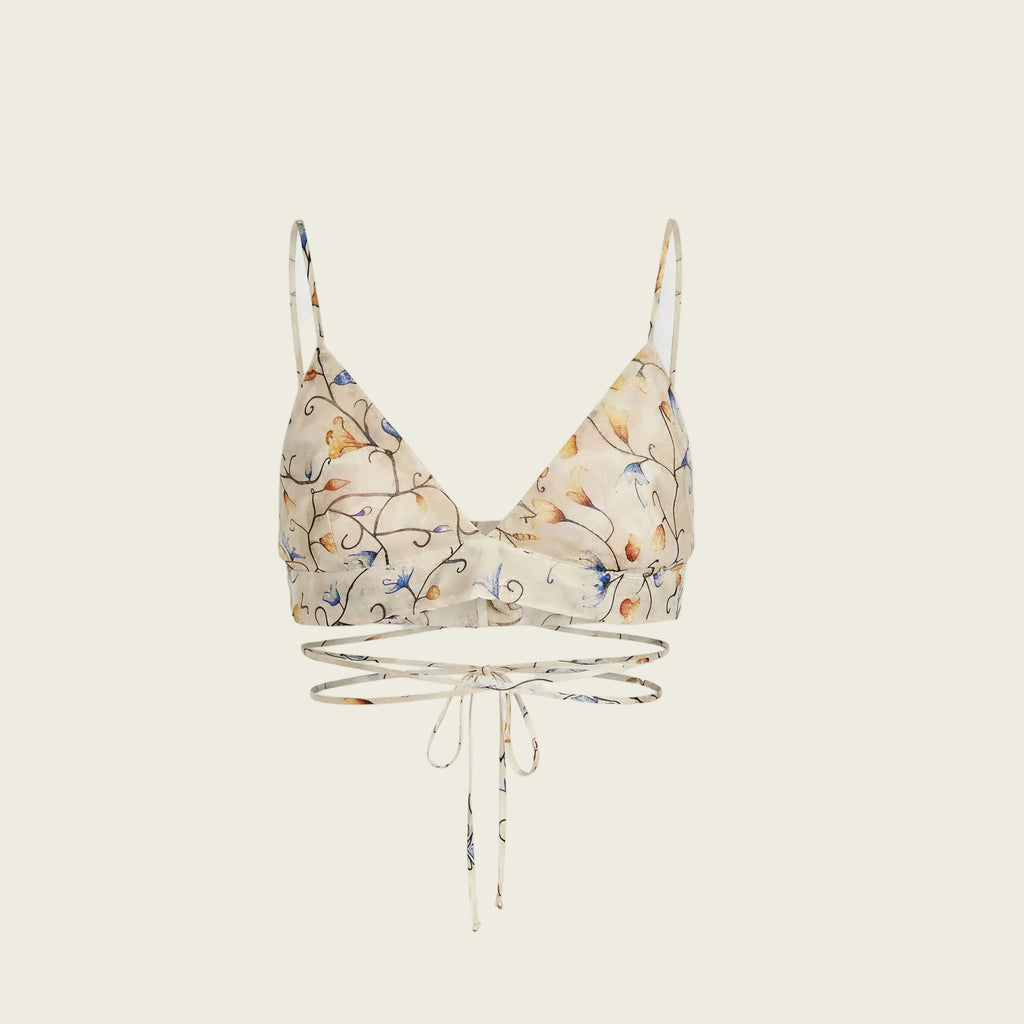 A beige triangle bralette with a delicate blue and orange floral pattern, featuring thin shoulder straps and a matching beige underwire band with a front tie closure, displayed against a solid white background.