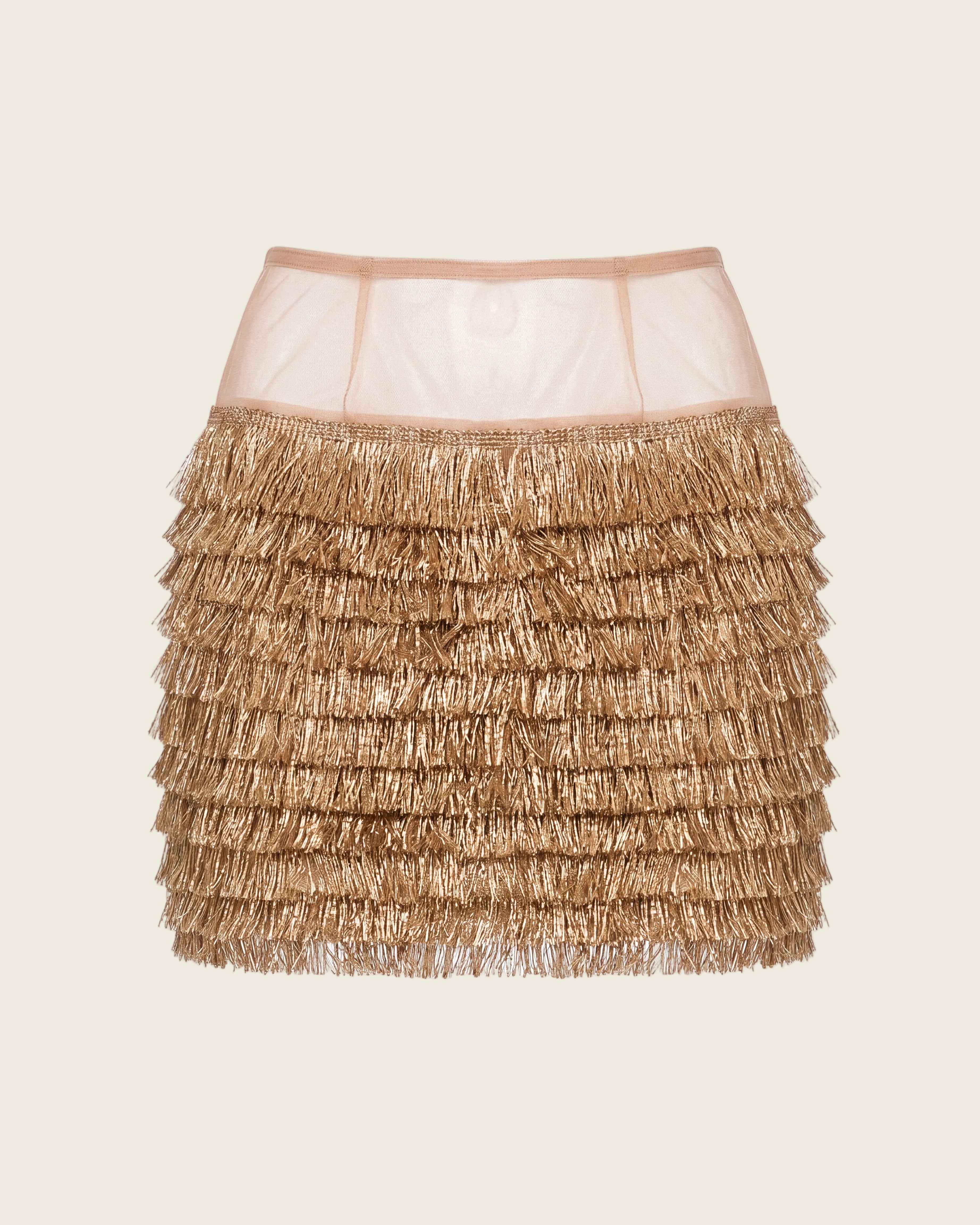 A metallic gold fringed mini skirt with a sheer nude mesh waistband, shown against a plain white background.