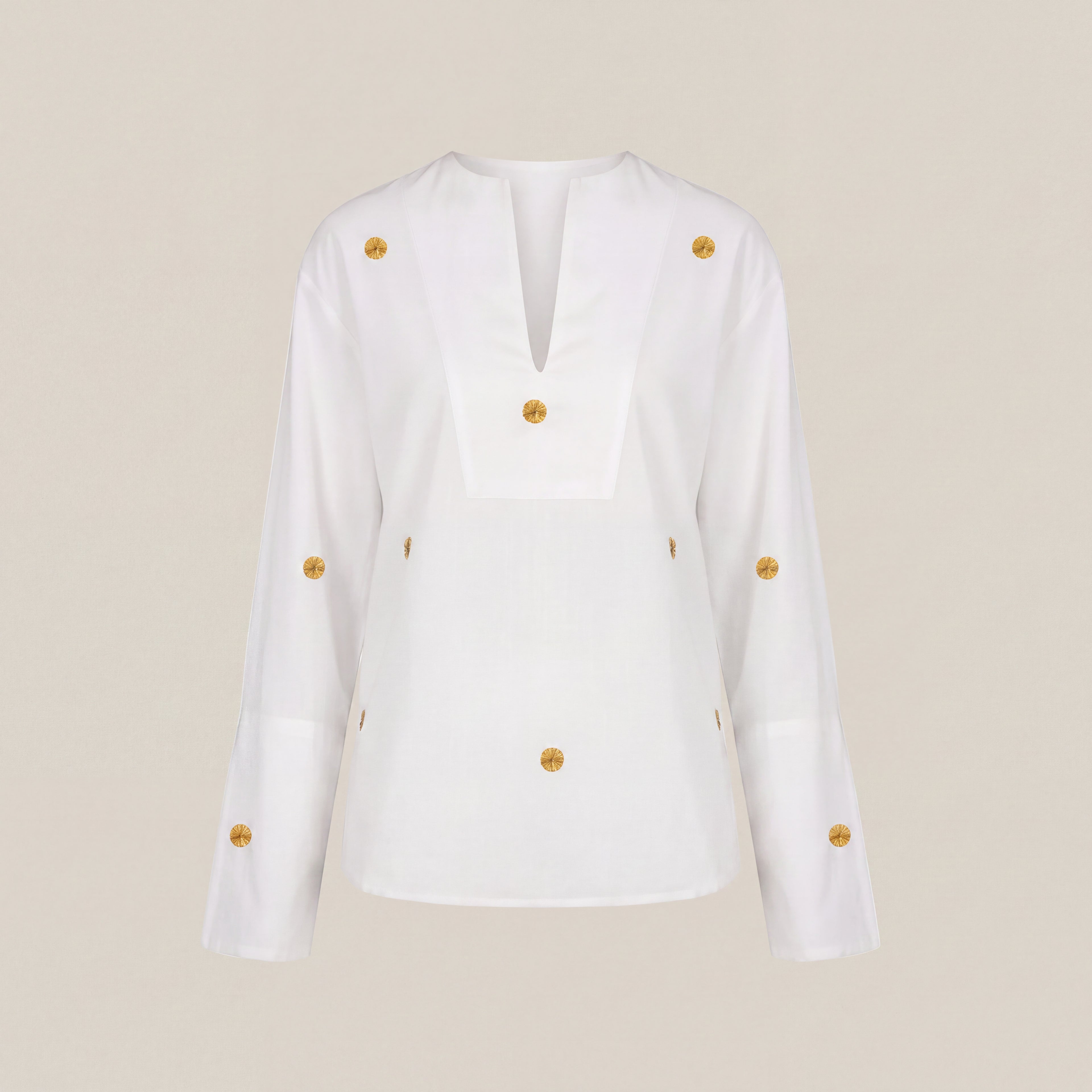 A white long-sleeve blouse with a split V-neckline and multiple decorative gold buttons, shown against a solid beige background.