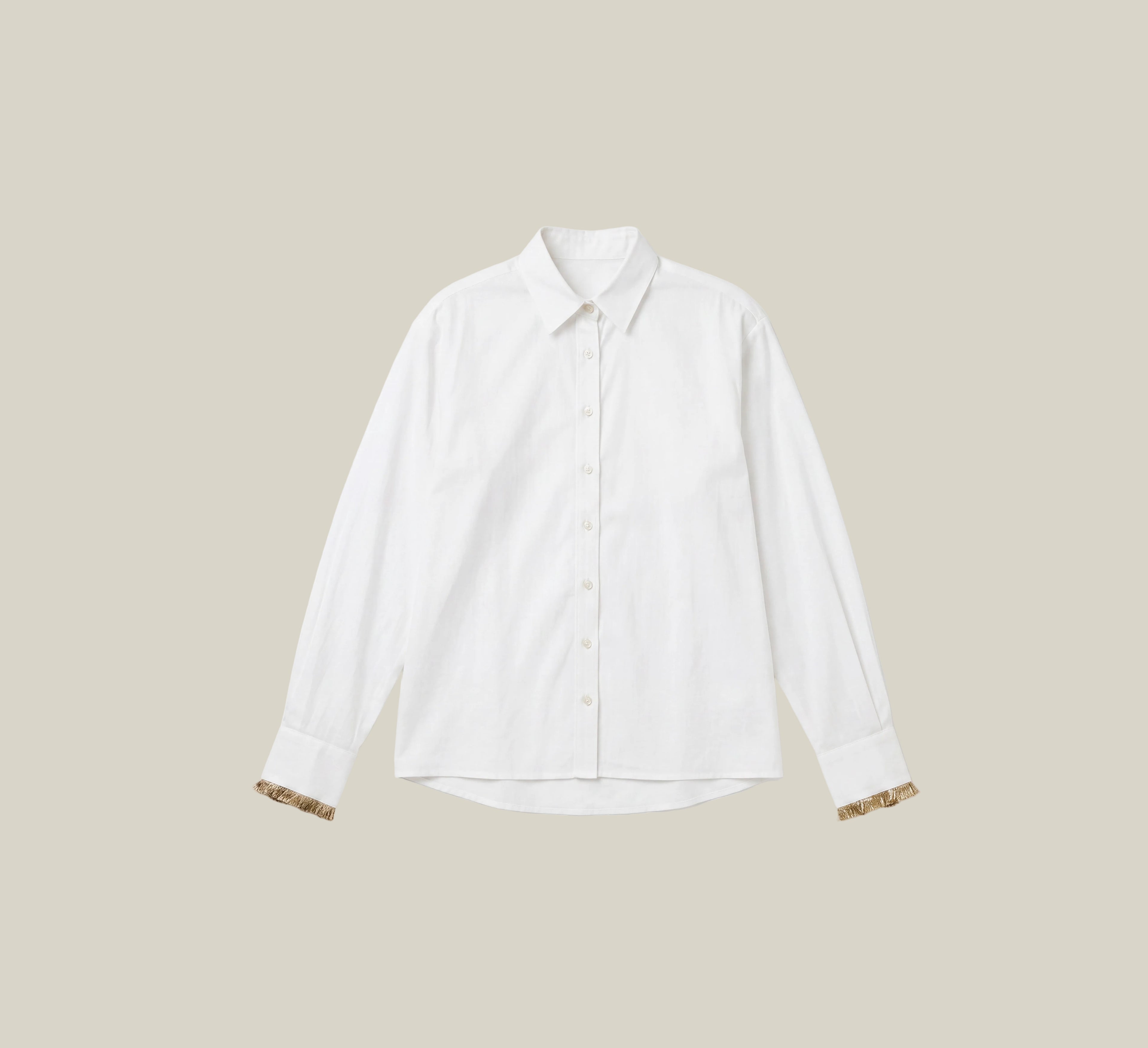 A white long-sleeve button-up shirt with patterned cufflinks, displayed flat against a light cream background.