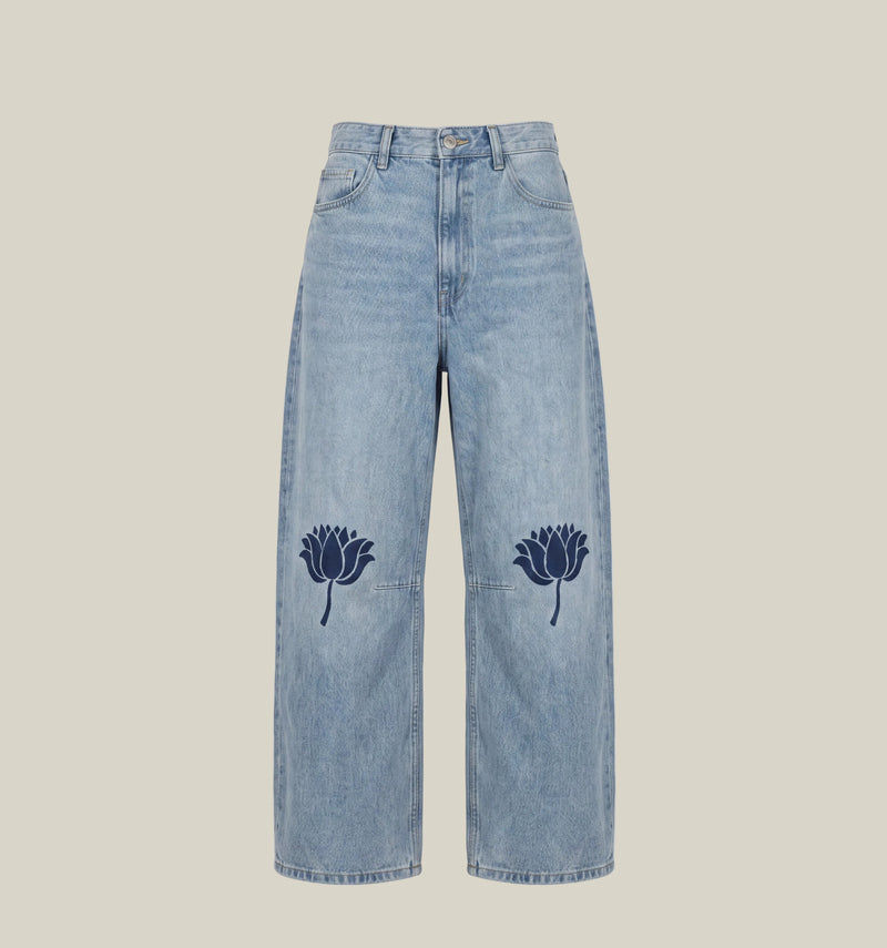 Light blue wide-leg denim jeans with dark navy embroidered lotus flowers on each leg, shown flat against a white background.
