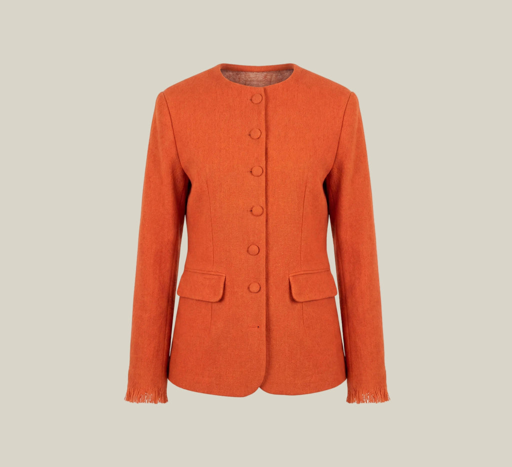 An orange textured jacket with a round neckline, button-front closure, and flap pockets, presented on a white card against a light beige background.