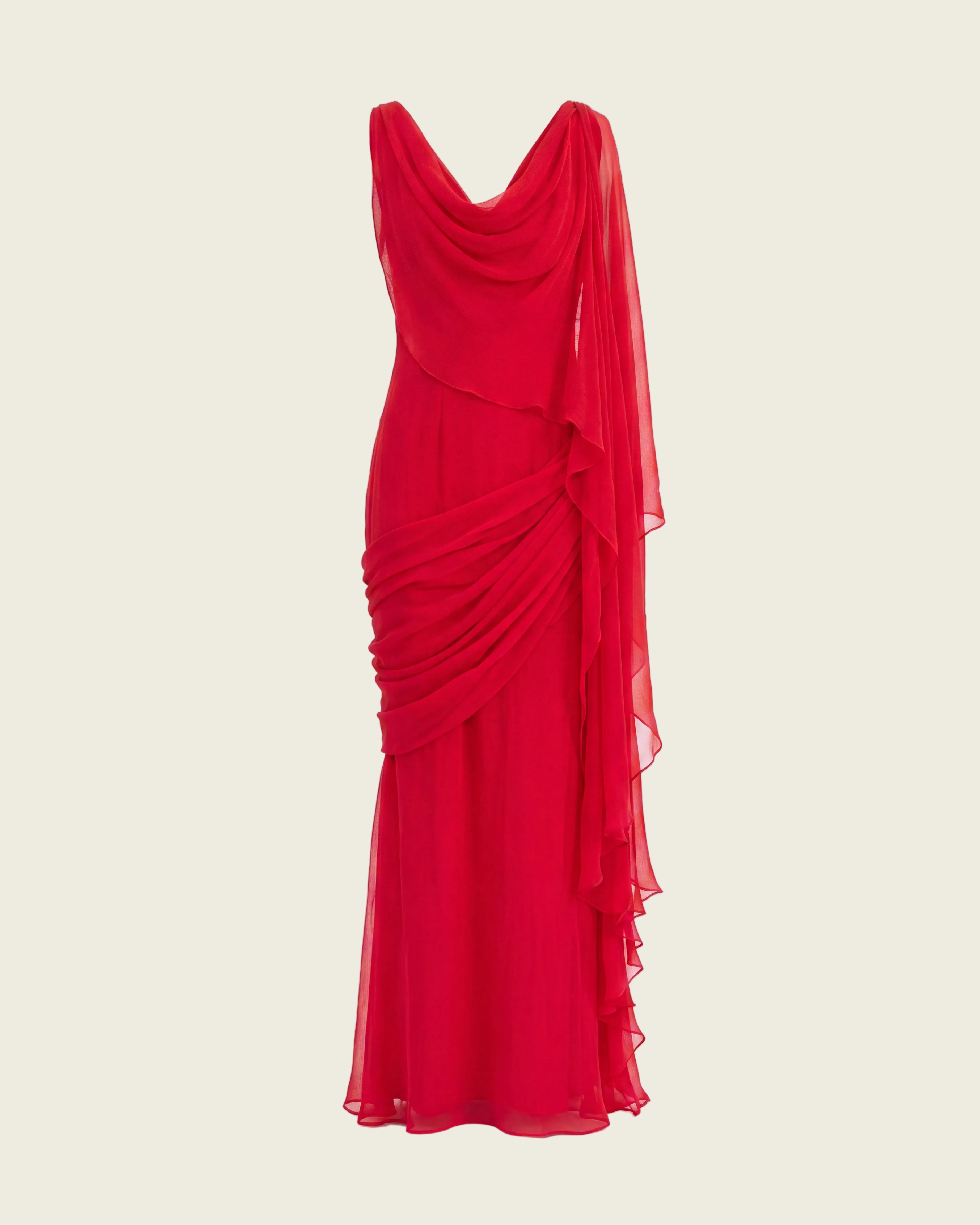 A vibrant red draped gown with a V-neckline, flowing sheer side drape, and gathered ruching on a plain white background.