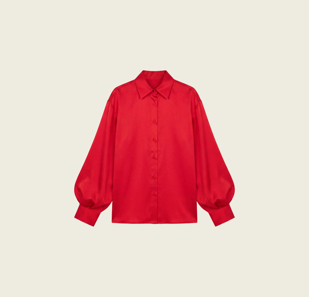 A bright red long-sleeve button-up shirt with a pointed collar and voluminous balloon sleeves, shown flat against a white background with a beige border.