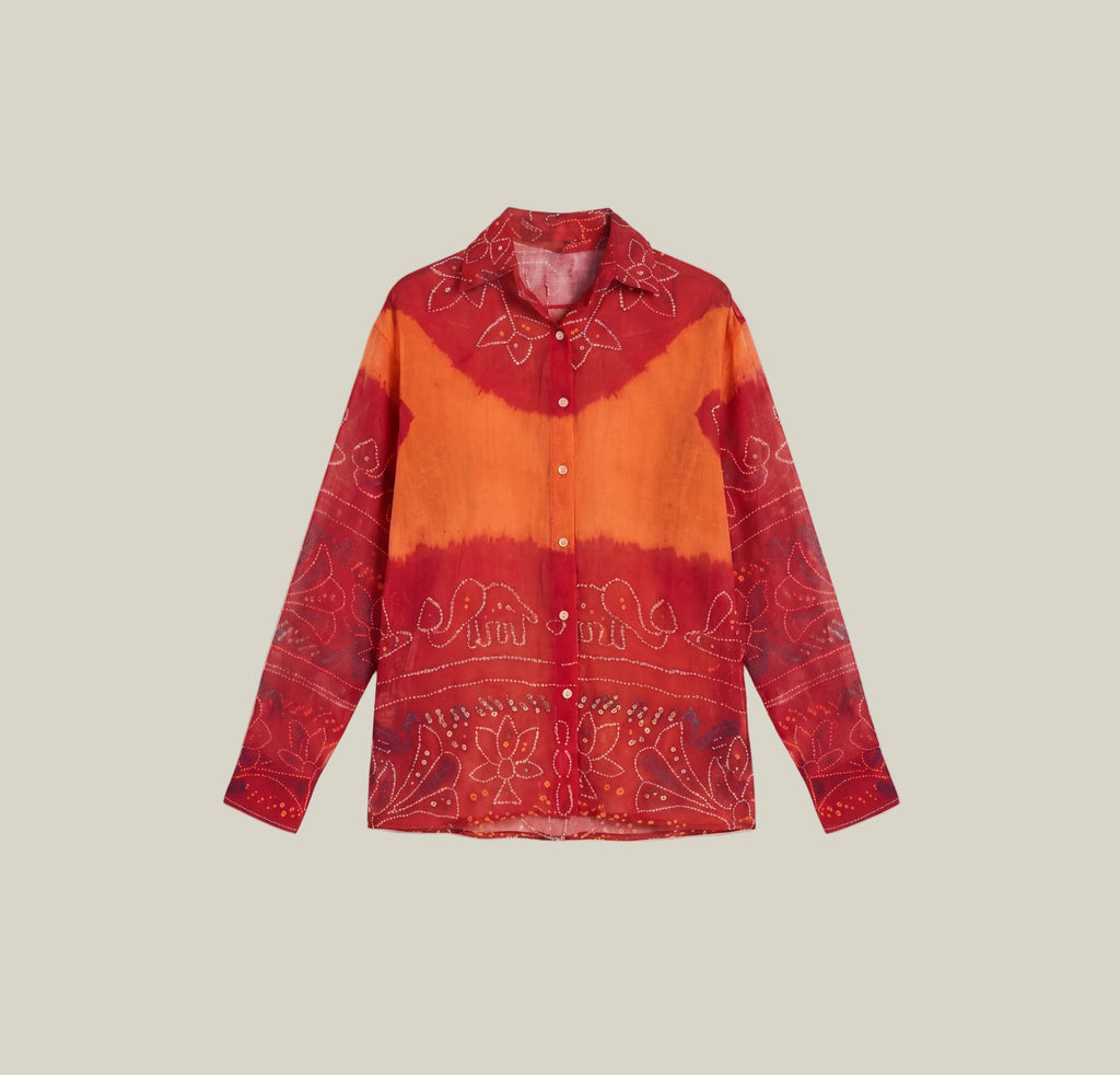 A long-sleeve button-up shirt with a red and orange tie-dye pattern and white paisley embroidery, displayed flat against a light beige background.