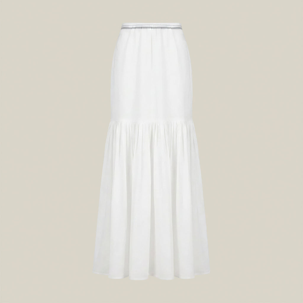 A white tiered midi skirt with a gathered waistband, displayed on a neutral beige background.